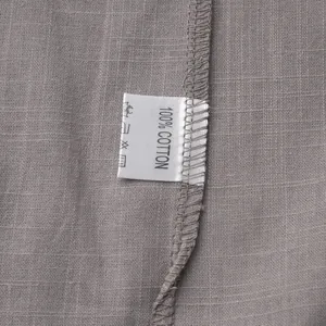 Detailed macro view showing the 100% cotton material tag and fabric texture of the set