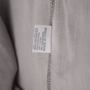Close-up of the care label on a grey cotton casual loungewear set showing washing instructions