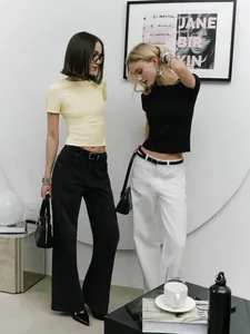 Fashionable slim fit crop top t-shirts in yellow and black worn by models in a studio