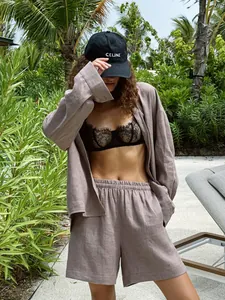 Woman wearing a casual mauve long-sleeve shirt and shorts set in a tropical outdoor setting