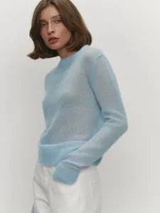 Side view of a light blue semi-sheer mohair sweater worn by a female model