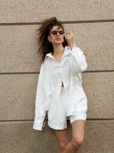 Model wearing white pure cotton long-sleeved shirt and matching shorts in lifestyle setting