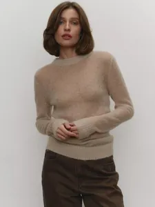 Close-up of beige semi-transparent mohair knit sweater with soft texture and round neck.