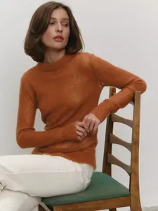 Chic orange mohair sweater detail showing semi-sheer texture and ribbed cuffs