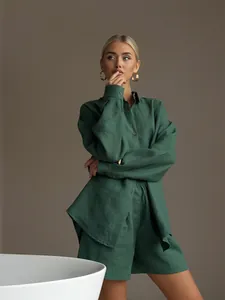 Detail view of women's green long-sleeve shirt and shorts set with linen texture