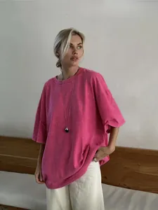 Oversized acid-wash pink t-shirt with loose fit shown on a model in a minimal room