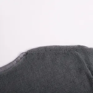 Detailed macro view of a grey transparent thin knit sweater showing fine texture and seam.