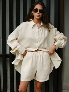 Relaxed beige linen two-piece set featuring oversized long-sleeve shirt and matching shorts