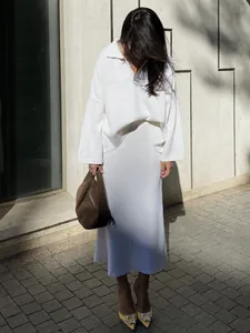 Elegant minimalist white knit two-piece set featuring V-neck sweater and midi skirt
