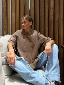 Lifestyle view of a brown oversized washed T-shirt with a vintage faded texture.