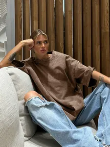Woman wearing a vintage acid wash brown oversized T-shirt in a relaxed casual setting