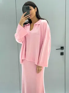 Stylish pink V-neck knit sweater and midi skirt two-piece set for winter fashion.