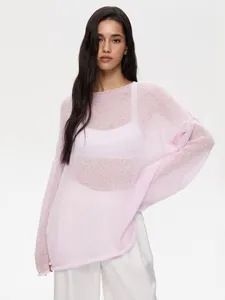 Sheer pink hollow-out knit sweater with flared sleeves and wide neckline on model