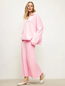Minimalist pink knitted two-piece set with V-neck sweater and maxi skirt for winter.