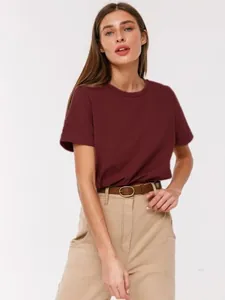 Professionelle Detailaufnahme eines weichen weinroten Baumwoll-T-Shirts mit Rundhalsausschnitt