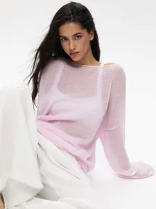Close-up view of a pink hollow-out see-through knit sweater with elegant bell sleeves.