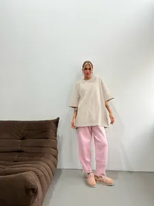 Oversized washed beige t-shirt paired with pink distressed knit joggers for a relaxed look
