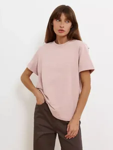 Frau im staubrosa T-Shirt mit Rundhalsausschnitt, Detailaufnahme der Vorderseite.