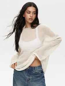 Close-up of white sheer hollow-out knit sweater with mesh texture and wide round neck.