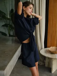 Model wearing navy linen shirt and shorts set in a luxury resort interior setting