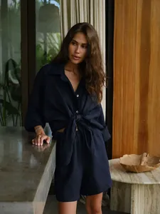 Model showcasing a dark navy linen-blend resort set in an elegant tropical villa setting