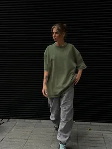 Lifestyle shot of an oversized olive green washed distressed cotton T-shirt