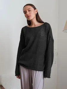 Close-up of a charcoal grey lightweight oversized knitted top with round neck detail.