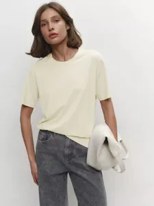 Modernes Damen T-Shirt mit Rundhalsausschnitt in Creme, kombiniert mit grauen Jeans