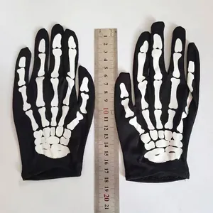 Detail showing kids' black Halloween skeleton gloves with a ruler for size reference.
