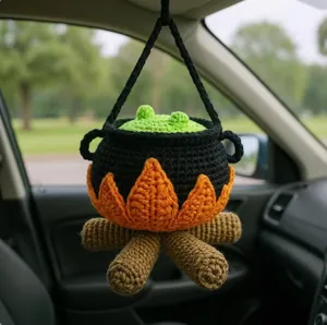 Detailed macro view of handcrafted crochet Halloween cauldron hanging ornament in car interior