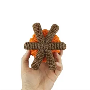 Detailed view of handmade crochet Halloween cauldron with orange and brown yarn