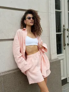 Stylish women wearing a casual pink linen-blend shirt and matching shorts set outdoors