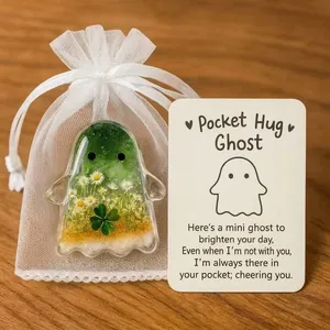 Close-up of a resin pocket ghost ornament with a mesh bag and a cheering message card
