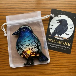 Handcrafted crow-shaped pocket hug token with Halloween pumpkin design and message card.