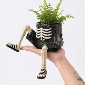 Vue détaillée d'un pot de fleurs suspendu en forme de squelette d'Halloween.