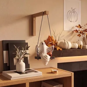 Détail d'une figurine de fantôme blanc effrayant sur une balançoire en bois pour Halloween