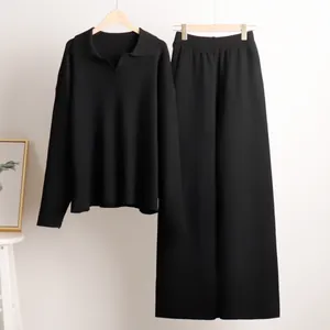 Detail view of a black two-piece knitwear set with Polo collar sweater and wide-leg trousers