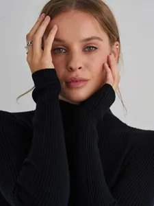 Close-up of women's black ribbed mock neck sweater showing detailed slim knit texture