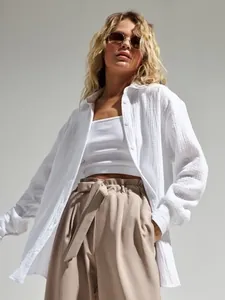Dettaglio di camicia oversize in cotone bianco stropicciato, tessuto traspirante