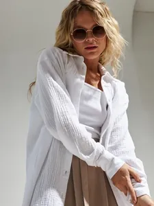 Dettaglio di una camicia a maniche lunghe in cotone stropicciato bianco su modella