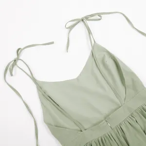 Close-up of sage green cotton dress featuring tie-up straps and open back detail