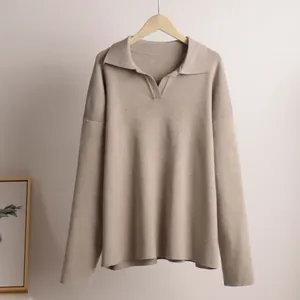 Detail of minimalist Polo collar knit sweater in taupe, hanging on wooden hanger