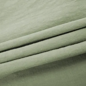 Detailed view of breathable sage green pure cotton fabric showing fine woven texture