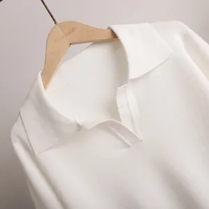 Detailed macro shot of white knitted Polo collar sweater showing soft fabric texture