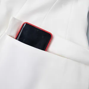 Dettaglio della tasca funzionale di un blazer bianco sciancrato professionale da donna.