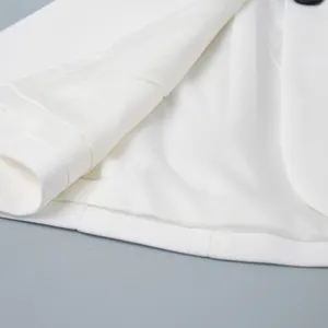 Vista dettagliata della fodera interna liscia del blazer bianco e del polsino della manica