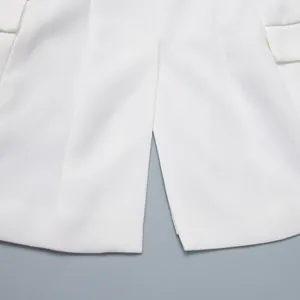 Dettaglio ravvicinato dello spacco sull'orlo di un elegante blazer bianco da donna