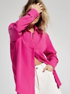 Dettaglio di una camicia rosa in cotone stropicciato a maniche lunghe traspirante