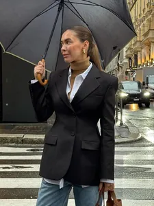 Elegante blazer nero slim-fit da donna, perfetto per uno stile professionale chic in città.