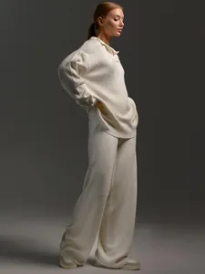 Side view of woman wearing cream knit polo sweater and matching wide-leg trousers